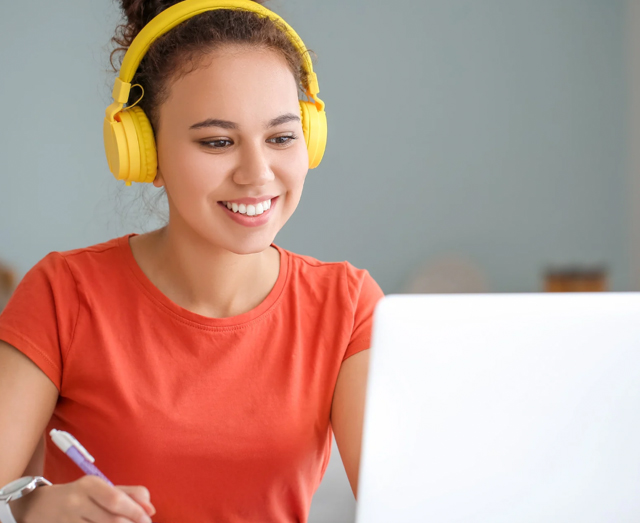 Person wearing headphones and using a laptop